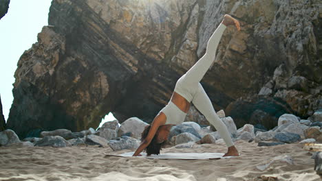 Frau-Macht-Nach-Unten-Gerichtete-Pose-Und-Praktiziert-Yoga-Auf-Sand-Am-Ursa-Beach,-Vertikal-Ausgerichtet