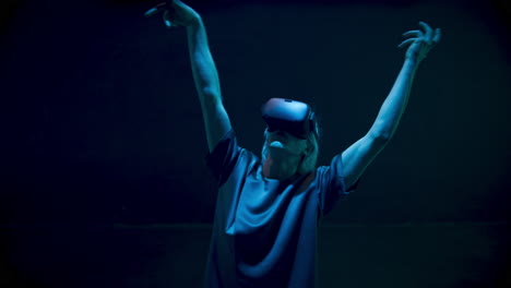 Neon-lights-gamer-dancing-in-virtual-reality-headset.-Energetic-man-enjoying