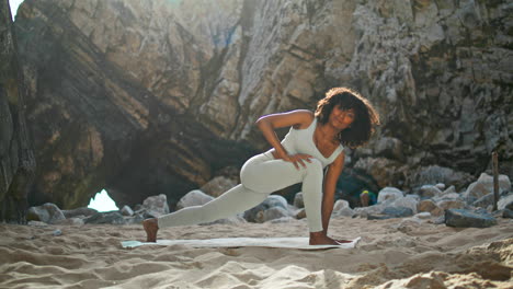 Woman-standing-utthita-parsvakonasana-pose-on-beach.-Girl-training-yoga-asana.
