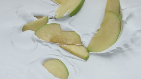 Manzana-Verde-Cayendo-Yogur-En-Cámara-Súper-Lenta-De-Cerca.-Postre-Lácteo-Orgánico.