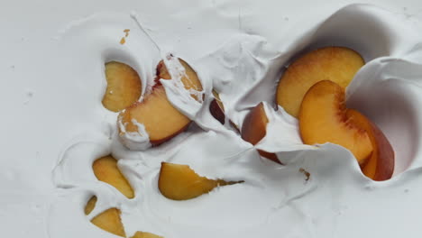 Natural-yogurt-pieces-peach-background-close-up.-Fruit-falling-on-creamy-dessert