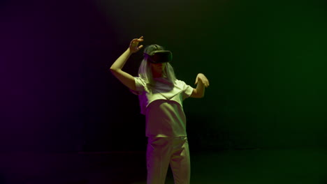 Neon-Mädchen-Tanzt-VR-Headset.-Energiegeladener-Teenager-Genießt-Metaverse-Simulation