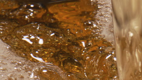 Lager-beer-swirling-goblet-closeup.-Sparkling-liquid-moving-inside-glass-vessel
