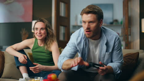 Excited-couple-competing-videogame-at-home.-Nasty-man-taking-gamepad-from-woman