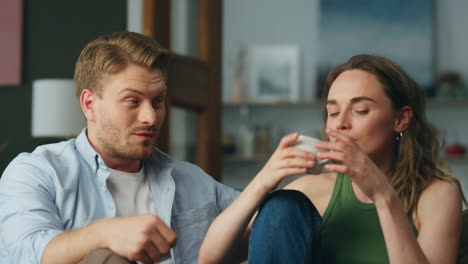 Talking-duet-drinking-tea-at-sofa-interior-closeup.-Calm-woman-sipping-coffee