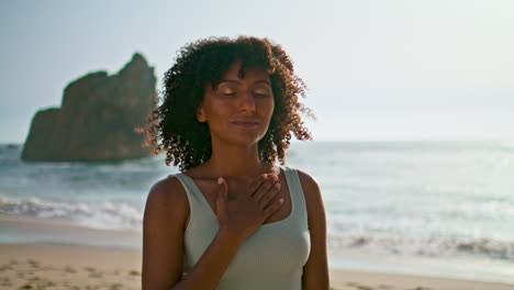 Mujer-Pacífica-Meditando-Cerca-De-La-Playa.-Niña-Poniendo-La-Mano-En-El-Pecho-Al-Amanecer
