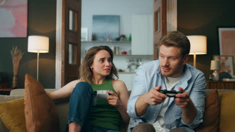 Losing-woman-hitting-husband-at-home-closeup.-Excited-gamer-holding-gamepad-pov