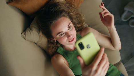 Positive-lady-speaking-cellphone-video-call-closeup.-Relaxed-woman-laying-sofa