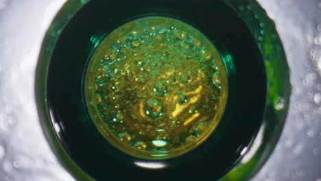 Lager-falling-splashing-flask-closeup.-Golden-alcohol-drink-overflowing-top-view