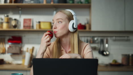 Girl-enjoy-remote-work-at-kitchen-in-headphones-close-up.-Woman-listening-music.