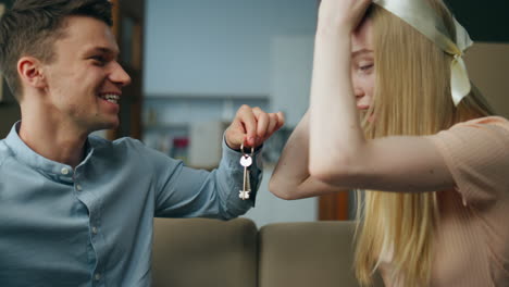 Husband-showing-keys-wife-from-new-home-close-up.-Woman-laughing-about-moving.