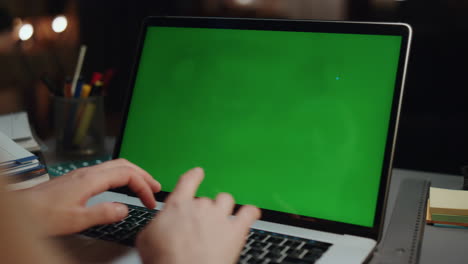 Student-hands-typing-chromakey-laptop-at-dark-room-closeup.-Woman-arms-texting