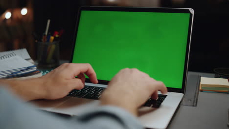 Freelancer-hands-texting-greenscreen-laptop-dark-room-closeup.-Man-arms-typing