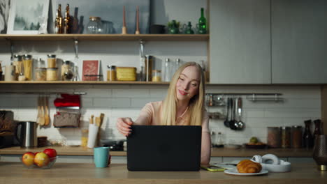 Woman-finish-video-call-closing-laptop-on-kitchen.-Girl-manager-working-remotely