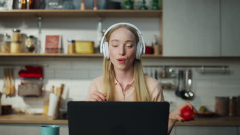 Woman-freelancer-dancing-laptop-in-headphones-close-up.-Girl-resting-from-work.