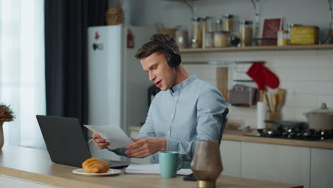 Telearbeiter-Hört-Musik-über-Kopfhörer-Und-Arbeitet-In-Der-Küche-Zu-Hause-Mit-Einem-Laptop.