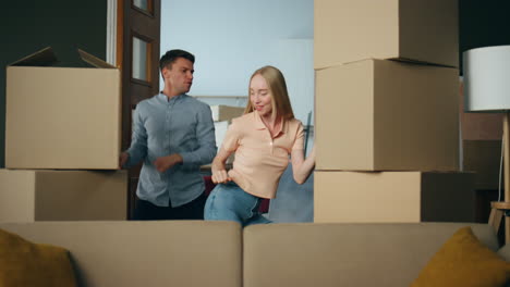 Couple-dancing-new-apartment-between-packed-boxes.-Family-moving-in-flat.