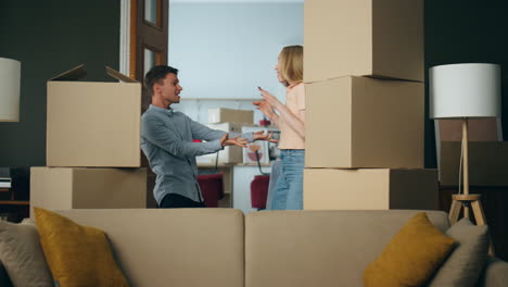 Family-have-fun-moving-in-new-house-dancing-between-carton-packed-boxes.