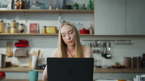 Businesswoman-talking-video-conference-at-kitchen.-Woman-working-remotely.