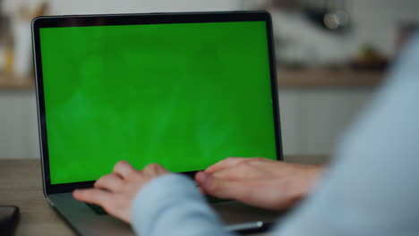 Hands-typing-greenscreen-laptop-at-home-close-up.-Freelancer-working-on-computer