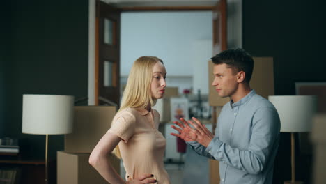 Millennial-couple-discussing-disagreement-at-home-gesturing-emotionally-close-up