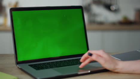 Woman-working-greenscreen-laptop-at-kitchen-close-up.-Hands-scrolling-touchpad.