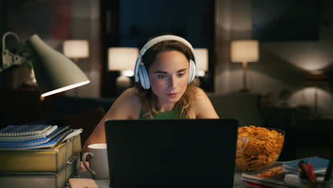 Thoughtful-freelancer-pondering-laptop-at-home-closeup.-Woman-listening-music