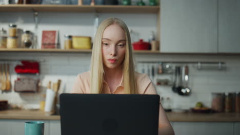 Woman-working-remotely-kitchen-with-laptop-closeup.-Girl-have-online-job.