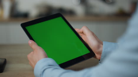 Hands-touching-greenscreen-tablet-searching-information-sitting-at-table-closeup
