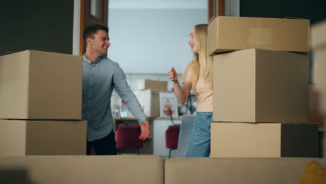 Happy-couple-homeowners-hugging-entering-new-house-with-cardboard-boxes.