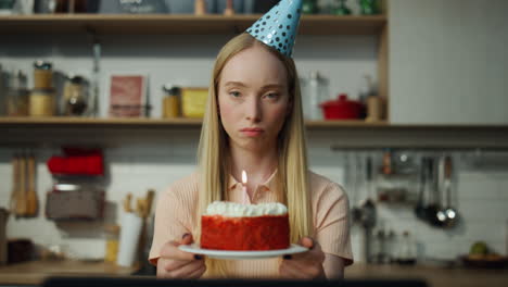 Unhappy-woman-celebrating-birthday-alone-with-cake-looking-in-webcam-close-up.