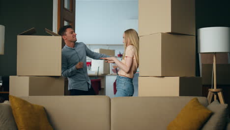 New-homeowners-funny-dancing-between-packed-boxes-celebrating-buying-property.