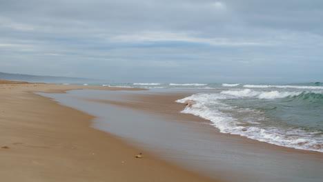 Waves-washing-ocean-shore-on-gloomy-day-vertical-view.-Peaceful-zen-like-spot