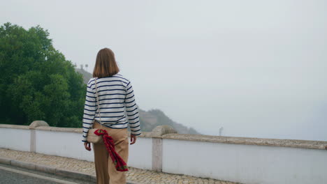 Girl-walking-city-bridge-rear-view-vertical.-Lonely-tourist-travel-explore-town