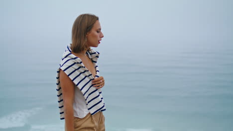 Girl-walk-ocean-view-on-cliff-top-vertical.-Upset-young-woman-contemplating-life
