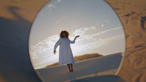 Mirror-reflecting-woman-dance-at-sand-desert-in-front-sunset.-Girl-performance.