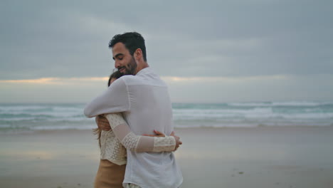 Carefree-newlyweds-cuddling-evening-beach-closeup.-Smiling-man-kissing-woman