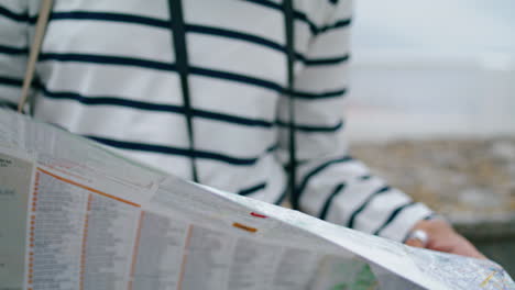 Tourist-hands-holding-map-in-old-seaside-town-closeup.-Lost-girl-exploring-city