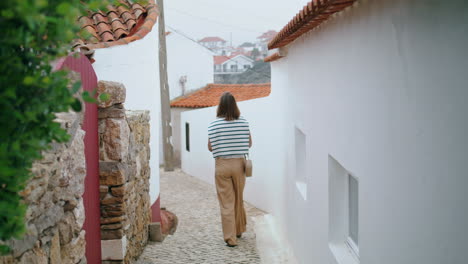 Romantic-girl-walking-old-narrow-street-vertical.-Carefree-tourist-explore-city