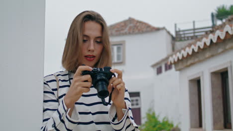 Girl-taking-old-camera-photos-at-whitewashed-houses.-Beautiful-tourist-travel