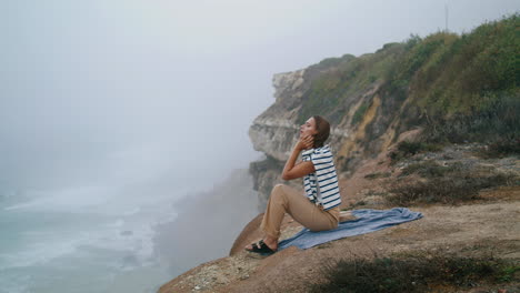 Woman-stretching-sea-cliff-on-summer-vacation-vertical.-Calm-tourist-enjoy-ocean