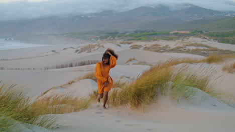 Woman-running-sandy-dunes-seashore-at-gloomy-summer-evening.-Girl-jogging-desert