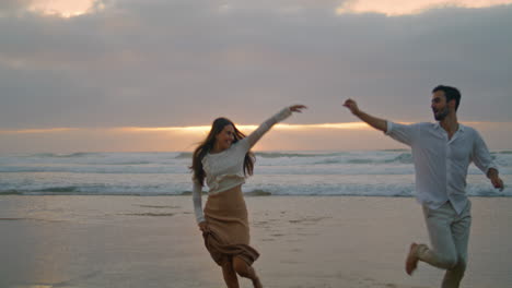 Love-couple-running-ocean-beach-sunset-together.-Ethnic-lovers-enjoying-on-date