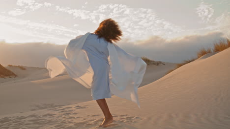 Woman-waving-fluttering-cloth-dancing-on-dunes-summer-sunset.-Girl-performing.