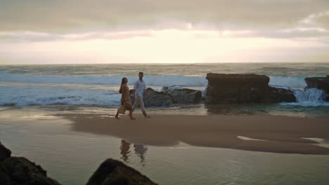 Affectionate-couple-going-sea-shore-wide-shot.-People-enjoying-romantic-time