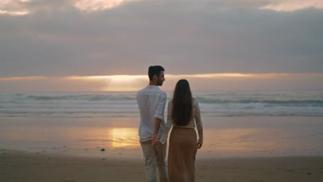 Young-spouses-relaxing-sunbeams-beach-cloudy-evening.-Lovers-walking-vertically