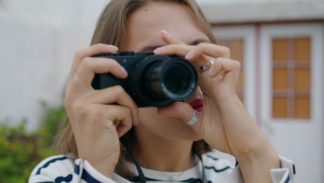 Closeup-girl-taking-picture-on-analog-camera.-Beautiful-tourist-adjusting-lens