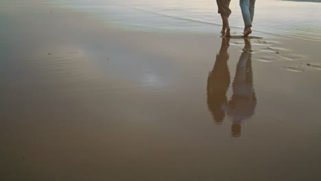 Lovers-feet-walking-sand-beach-vacation.-Uncnown-couple-stepping-shore-vertical