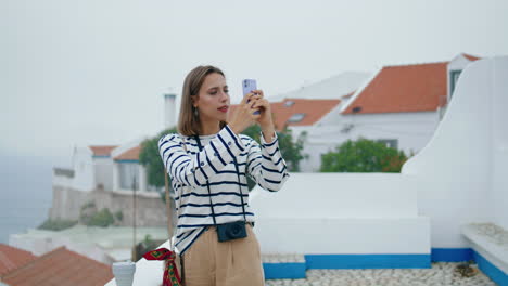 Travel-girl-taking-smartphone-pictures-on-rooftop-vertical.-Tourist-explore-town