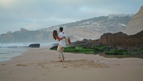 Love-couple-having-fun-in-marine-vacation.-Gentle-man-carrying-wife-on-sea-beach